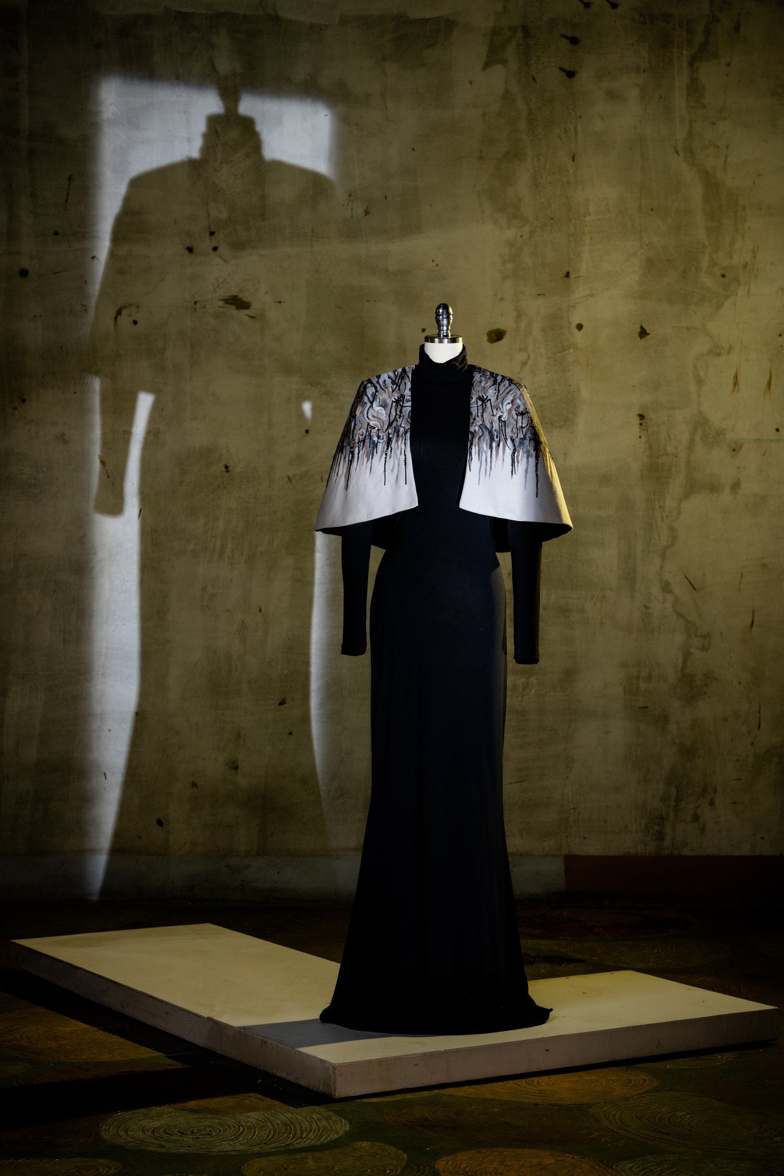 A hand-painted capelet over a black column gown from The Hope Collection