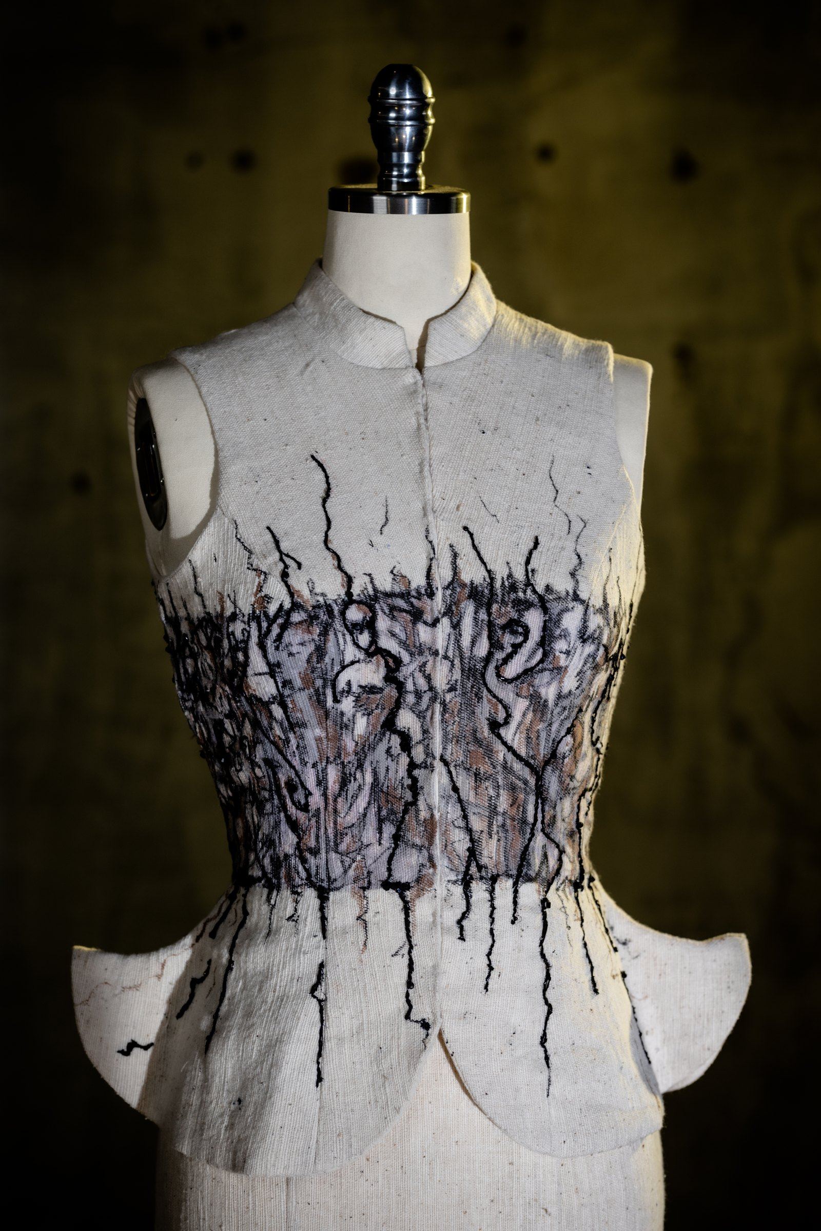 The painted corset bodice on the stand, showing the petal peplum